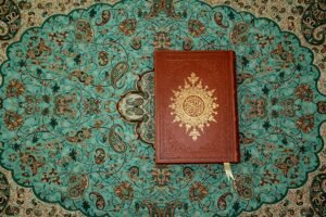 Top view of a Quran on a richly patterned Islamic art motif in Kashan, Iran.